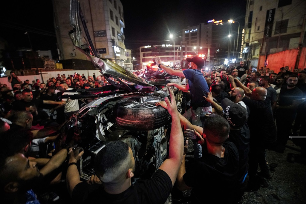 مواطنون يتفقدون المركبة التي قصفها الاحتلال واستشهد داخلها الشابين دواسي وأبو عرة وسط مدينة جنين (تصوير: محمد منصور/وفا)